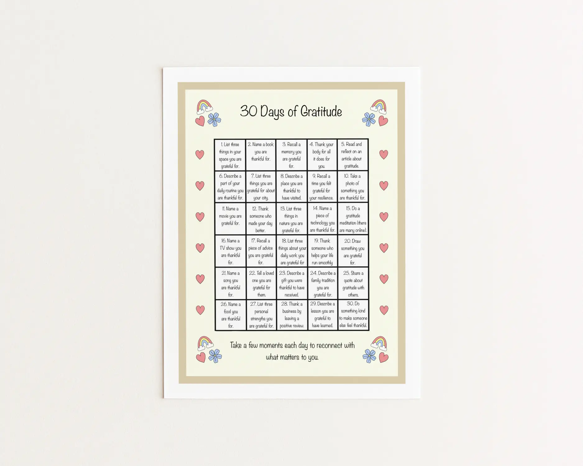 A printed page with the title "30 days of gratitude." It contains a central grid filled with 30 of my favorite gratitude prompts. It is decorated with hand-drawn motifs of hearts, rainbows, and blue flowers.